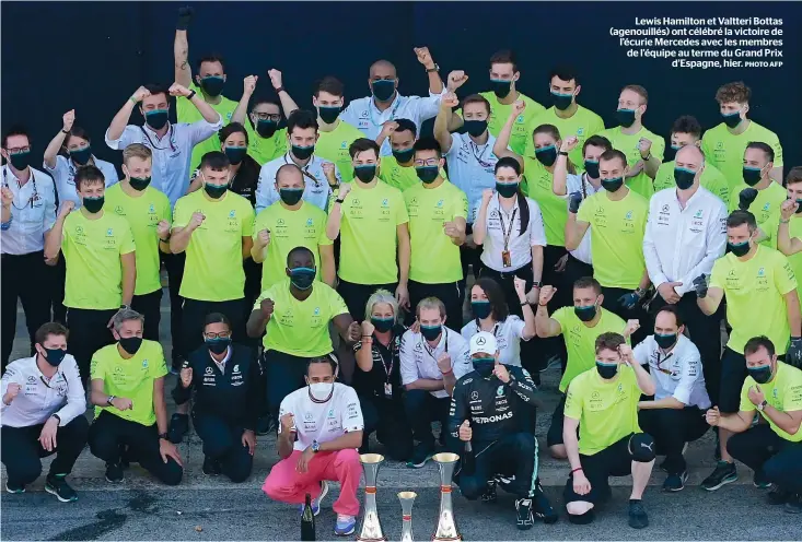  ?? PHOTO AFP ?? Lewis Hamilton et Valtteri Bottas (agenouillé­s) ont célébré la victoire de l’écurie Mercedes avec les membres de l’équipe au terme du Grand Prix
d’espagne, hier.