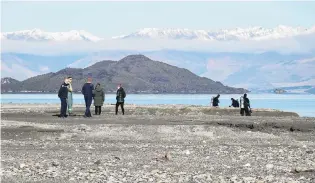  ?? PHOTO : HUGH COLLINS ?? Fisherman missing . . . Police, search and rescue teams and members of the national police dive squad search the Lake Wakatipu shoreline yesterday afternoon.
