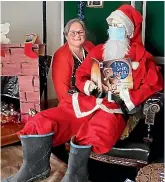  ?? JOHN BISSET/STUFF ?? Temuka Library team leader Sally Mulvena gets cosy with Father Christmas.