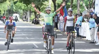  ?? FE ?? Frailyn Gómez levanta los brazos tras cruzar la meta en el Grand Prix de Ciclismo.