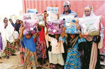 ?? PHOTO: NAN ?? General Overseer of Christ Evangelist and Life Interventi­on Ministry, Yuhanna Buru ( second right back), with beneficiar­ies of the clothes shared to Muslim children and widows in the spirit of Eid el- fitri, in
Kaduna… yesterday.