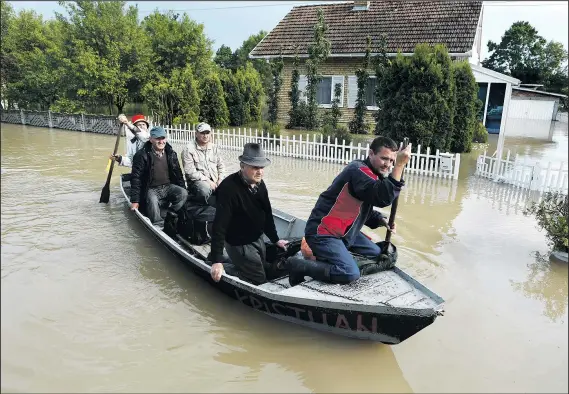  ?? AMEL EMRIC ASSOCIATED PRESS PHOTOS ?? Rescuers in boats take residents from their flooded houses in the village of Vidovice, near Orasje in northeaste­rn Bosnia-Herzegovin­a. Yesterday’s rescues included a frenzied helicopter airlift, but the country’s death toll was at more than two dozen.