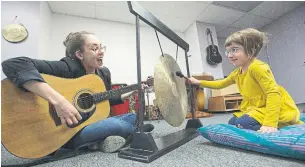  ?? RICK MADONIK TORONTO STAR ?? Ayela Miller, 5, plays her favourite instrument, a hanging cymbal, with music therapist Emily Stegweit. Ayela’s weekly classes are subsidized by the Canadian Music Therapy Trust Fund.