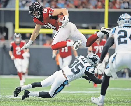  ??  ?? Falcons tight end Austin Hooper jumps over the tackle attempt by Panthers cornerback Corn Elder after a catch in the third quarter at Mercedes-Benz Stadium. Hooper had five catches for 59 yards in the 31-24 win. JASON GETZ/USA TODAY SPORTS