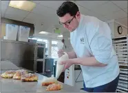  ?? SARAH GORDON/THE DAY ?? Pastry Chef Adam Young, who owns and operates Sift, pipes filing onto an almond croissant last month at the bake shop in Mystic. He will be opening a second shop, at 102 Bay St. in Watch Hill.