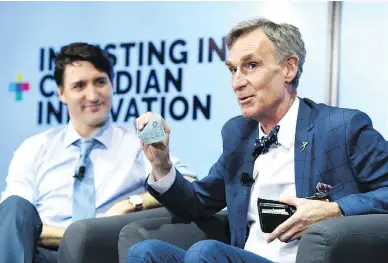  ?? JUSTIN TANG / THE CANADIAN PRESS ?? Bill Nye shows off a Canadian $5 bill, which features an astronaut and the Canadarm, as Prime Minister Justin Trudeau looks on during an armchair discussion highlighti­ng Canadian innovation at the University of Ottawa on Tuesday.