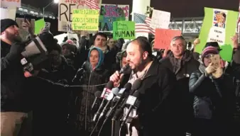  ?? | JACOB WITTICH/ SUN- TIMES ?? Hatem Abudayyah, of the Arab American Action Network, is cheered by a crowdat O’Hare on Sunday night while calling on President Donald Trump’s executive order to be rescinded.