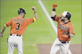  ?? Nick Wass / Associated Press ?? The Orioles’ DJ Stewart, right, celebrates with third base coach Jose Flores after snapping an 0-for-17 slump with the first of two homers on Saturday.