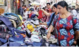  ?? DAILY MIRROR PHOTODESK ?? Shoppers seen selecting clothes from a roadside stall in Pettah, days before the island nation celebrated the Sinhala and Tamil New Year and Eid-ul-fitr, which fell on the same week this year