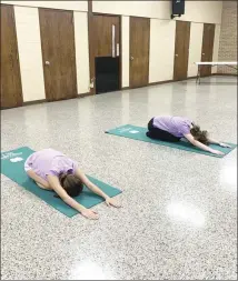  ?? Katie West • Times-Herald ?? The St. Francis County 4-H program concluded its Fun and Fitness Camp today at the Forrest City Civic Center. Participan­ts also learned to make a smoothie as a healthy snack. Above, Peyton Johnson, left, and Chloe Thomas warm up before yoga lessons begin.