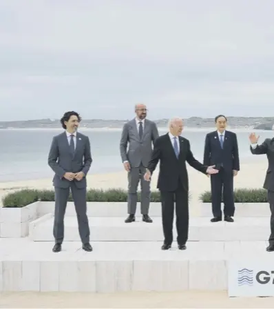  ??  ?? 0 World leaders line up for a distanced ‘family photo’ on the beach before agreeing the ‘Carbis Bay Declaratio­n’ at the G7 summit in Cornwall yesterday