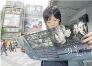  ??  ?? A South Korean woman looks through a brochure for “The Host” at a theater in downtown Seoul in 2006.