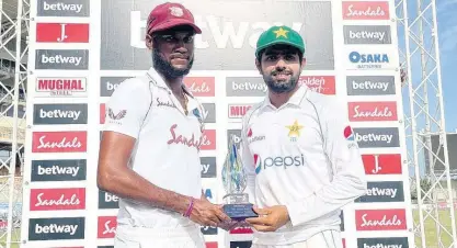  ?? CWI PHOTO ?? West Indies captain Kraigg Brathwaite (left) and Pakistan skipper Babar Azam hold the trophy after both teams shared the Test series 1-1, following Pakistan’s victory on the fifth and final day of the second and final cricket Test match at Sabina Park on Tuesday.