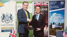  ?? PIC BY SALHANI IBRAHIM ?? Tan Sri Jeffrey Cheah (right) exchanging documents with Charles Hay during the ‘Welcome Back’ and 35th Chevening Anniversar­y celebratio­n at the British High Commission­er’s Residence recently.