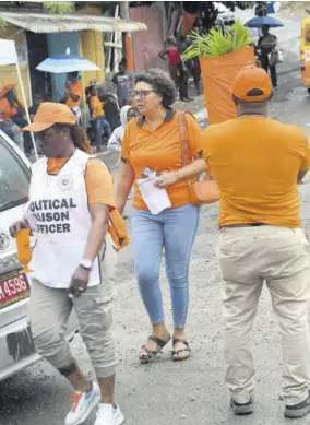  ?? (Photo: Collin Reid) ?? The People’s National Party’s Patricia Duncan-sutherland (centre) is seen working in the August Town Division on Monday during the local government elections.