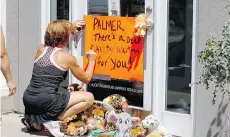  ?? ANN HEISENFELT/THE ASSOCIATED PRESS/THE CANADIAN PRESS ?? Protesters have flocked to Walter J. Palmer’s dental office in Bloomingto­n, Minn., to condemn his shooting of Cecil the lion.