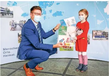  ??  ?? Die sechsjähri­ge Stella Heidelmann hat das Motiv für die Grußkarte der Stadt Erkelenz gemalt. Bürgermeis­ter Stephan Muckel überreicht­e ihr zum Dank Malutensil­ien.