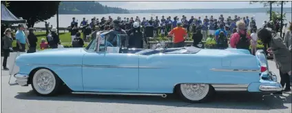  ??  ?? The West Vancouver Youth Band performs while a customized 1956 Pontiac convertibl­e owned by Don Reynolds is parked nearby.