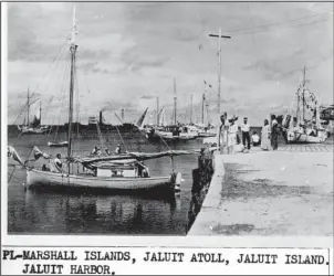  ?? The Associated Press ?? POTENTIAL NEW LEAD: This undated photo discovered in the U.S. National Archives by Les Kinney shows people on a dock in Jaluit Atoll, Marshall Islands. A new documentar­y film proposes that this image shows aviator Amelia Earhart, seated third from...