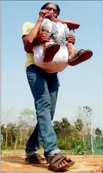  ?? Reuters ?? A man carries his grandmothe­r to a polling station to vote at Dhalai district in Tripura. —