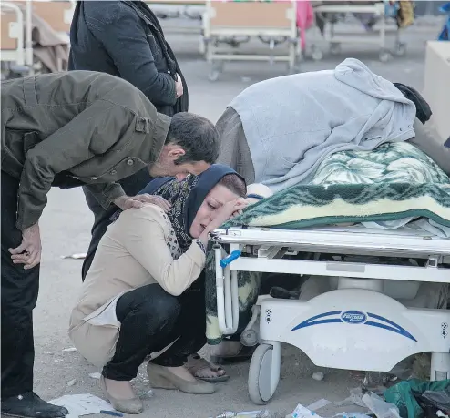  ?? FARZAD MENATI / TASNIM NEWS AGENCY VIA AP ?? Relatives weep over the body of an earthquake victim in Sarpol- e-Zahab, western Iran on Monday. A 7.3 magnitude earthquake struck the Iraq-Iran border region on Sunday night, toppling buildings and killing hundreds.