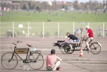  ??  ?? Cyclists on the tarmac watching people compete in a cargo bike race during a bicycle fair in Berlin — AFP photos by Odd Andersen