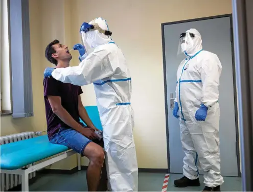  ?? FOTO: DPA PA / MARIUS BECKER ?? Corona-Test per Rachenabst­rich im Infektions­schutzzent­rum der Stadt Köln. Die Laborkapaz­itäten seien „endlich“, räumte Gesundheit­sminister Jens Spahn ein. Das ist eine späte Erkenntnis.