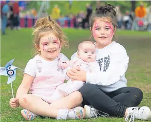  ??  ?? Lulu Red Anderson, 4, eight-week-old Mabel McNicol and Lorena Brankin, 6, pose for a photograph at the festival at Camperdown Park.