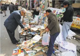  ?? Karim Kadim / Associated Press ?? Books are offered for sale on a Baghdad street, but libraries have become targets of militants, who carted away collection­s in Mosul.