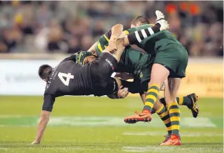  ?? Photo/ Photosport ?? Dean Whare gets attention from the Kangaroos. Later in the night, two team- mates were under scrutiny.