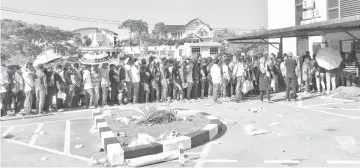  ??  ?? The crowd beating the sun as they queue at the Sabah Foo Chow Associatio­n hall for the consular service, yesterday.