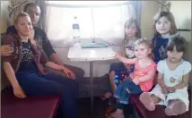  ?? ?? Devant la gare de Pokrovsk, qui a déjà reçu des missiles, des familles venues en autobus fuient les bombardeme­nts de l’armée russe. Parmi elles, figurent Nina et son mari Alexander, ainsi que leurs quatre enfants.