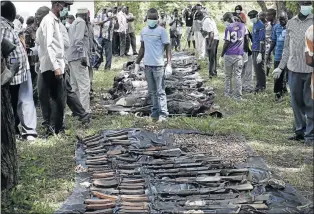  ?? PHOTO: GORAN TOMASEVIC/REUTERS ?? REVENGE: A morgue worker stands between the bodies of al-Shabaab fighters and their weapons in Mpekatoni, Kenya, on Monday. Kenya ’ s army said it also killed a regional commander of al-Shabaab