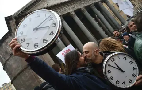  ?? ALBERTO PIZZOLI/AFP/GETTY IMAGES ?? Supporters of same-sex civil union kiss near the Pantheon in central Rome, holding alarm clocks “to wake up Italia.”