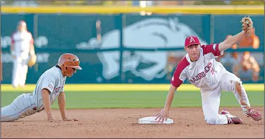  ?? NWA Democrat-Gazette/ANDY SHUPE ?? Arkansas shortstop Jax Biggers (right) shows the ball to the umpire after putting out Texas shortstop David Hamilton during the seventh inning Wednesday at Baum Stadium in Fayettevil­le.