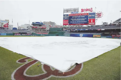  ??  ?? NICE TRY: A tarp covers the field as it is announced on the scoreboard the Washington Nationals’ exhibition game against the Red Sox at Nationals Park was cancelled yesterday. The teams will try to play today at the Naval Academy in Annapolis, Md.