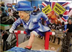  ?? KAI PFAFFENBAC­H Reuters ?? A papier mâché figure depicting Queen Elizabeth running for asylum towards the EU is seen during a presentati­on of the floats for the upcoming Rose Monday parade in Mainz, Germany. |