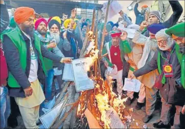  ?? PTI ?? Protesters burning copies of the Centre’s farm laws at the Delhi border on Lohri on Wednesday.