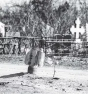  ?? PETROS GIANNAKOUR­IS AP ?? A part of a rocket still sits wedged on the ground following a Russian bombing earlier this week, at a cemetery in Mykolaiv, Ukraine, on Saturday.