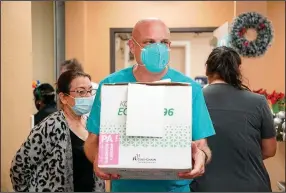  ?? (AP/Houston Chronicle/Godofredo A. Vasquez) ?? Dr. Joseph Varon, the chief medical officer at United Memorial Medical Center in Houston, carries in the facility’s first doses of Moderna’s covid-19 vaccine on Monday. The hospital, which serves primarily low-income and uninsured patients, did not receive any of the Pfizer vaccine last week.