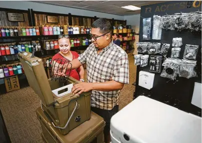  ?? Melissa Phillip / Houston Chronicle ?? Aleida and Alexander Arroyo of Houston shop Monday at the front room of Rtic’s Cypress warehouse, which serves as a retail store. The company plans to build a 10,000-square-foot flagship store to expand its footprint.