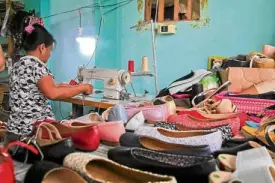  ??  ?? Sewer Maribel Alomia, 45, works on a shoe part at a home shoemaking workshop in Liliw, Laguna.