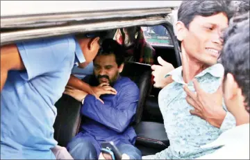  ??  ?? Members of the Rapid Action Battalion (RAB) of the Bangladesh police detaining top secular protester Imran Sarker (centre) for staging a protest against alleged the extrajudic­ial killings in Dhaka.