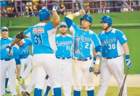  ??  ?? El veterano jardinero derecho de Las Piedras, Jorge Padilla, celebra en grande con sus compañeros su jonrón sabatino.