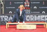  ?? RICH FURY / AGENCE FRANCE-PRESSE ?? Director Michael Bay puts his hands in cement during the ceremony at TCL Chinese Theatre IMAX on Tuesday in Hollywood.