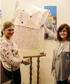  ?? Fotos: Gertrud Adlassnig ?? Martina und Gisela Weser entdeckten bei ihrer Enthüllung zwei Geländersp­rossen mit einem fröhlichen Vögelchen darauf, dahinter die leuchtende­n Gemälde von Gisela Sippel.