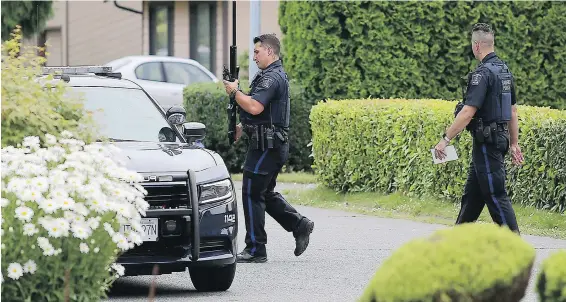  ??  ?? Saanich police respond to the scene where a man and a woman were shooting a pellet gun on Kincaid Street on Tuesday. The weapon was initially reported as possibly being a long-barrelled shotgun. Rogers Elementary was advised to lock its doors with staff and students inside.