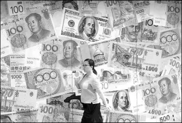  ?? AP ?? A woman walks by a money exchange shop decorated with different countries currency banknotes at Central, a business district in Hong Kong. China’s trade with the US fell sharply in August as a tariff war that threatens global economic growth worsened.