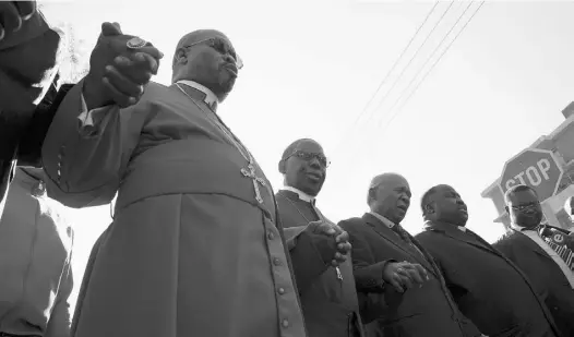  ?? AFP/ GETTY IMAGES ?? A dozen South African bishops pray Friday in Pretoria outside a hospital where former South African president Nelson Mandela has spent a week receiving treatment for a lung infection. Other well-wishers prayed outside Mandela’s Johannesbu­rg home for...