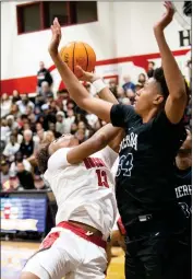  ?? PHOTO BY JOHN VALENZUELA ?? Centennial’s Eric Freeny, left, shoots and is fouled by Sierra Canyon’s Jimmy Oladokun during Friday’s CIF-SS Open Division boys basketball pool-play game won by Centennial.